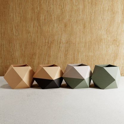 set of four geometric pots with varying colours against wooden background