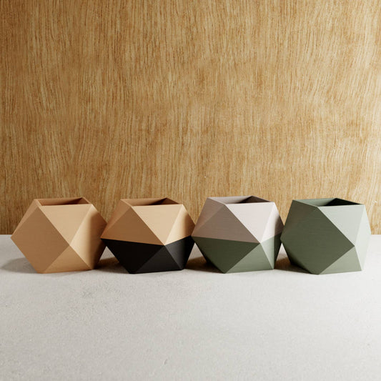 set of four geometric pots with varying colours against wooden background