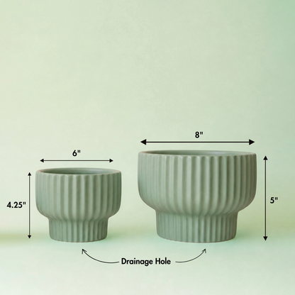 two jade coloured pedestal Presley planters with black test on the image showing the measurements of the pots against a jade background