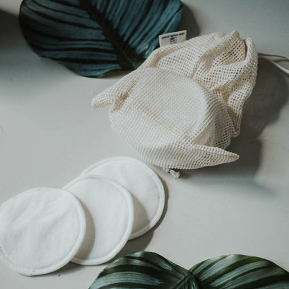 three white round reusable makeup remover pads on a white surface