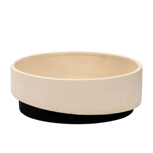 A two-tone matte ceramic planter with a low profile, primarily beige with a black base.