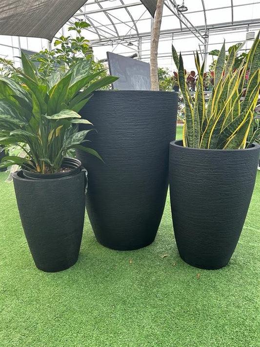 Three matte black conic planters of different sizes displayed outdoors, with various plants inside them.