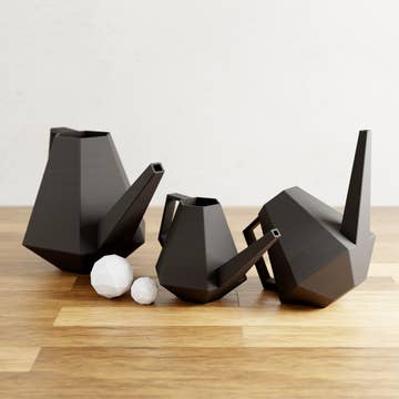 three black geometric watering cans of different sizes
