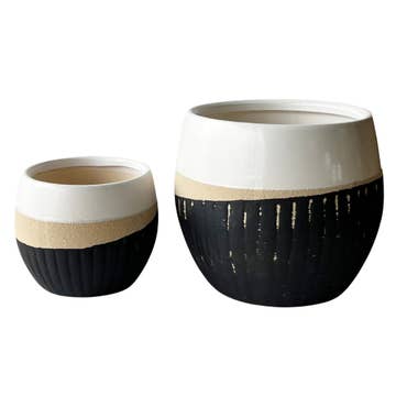 two multicoloured ceramic pots of different sizes against a white background