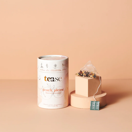 a tin of tease branded peach please tea next to a tea bag against a peach coloured background