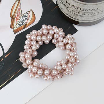 a pink toned pearl scrunchie resting on a table