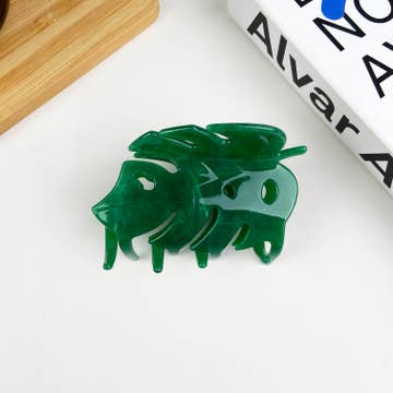 a green plant themed hair clip against a white background