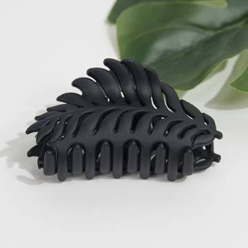 a black plant themed hair clip against a white background
