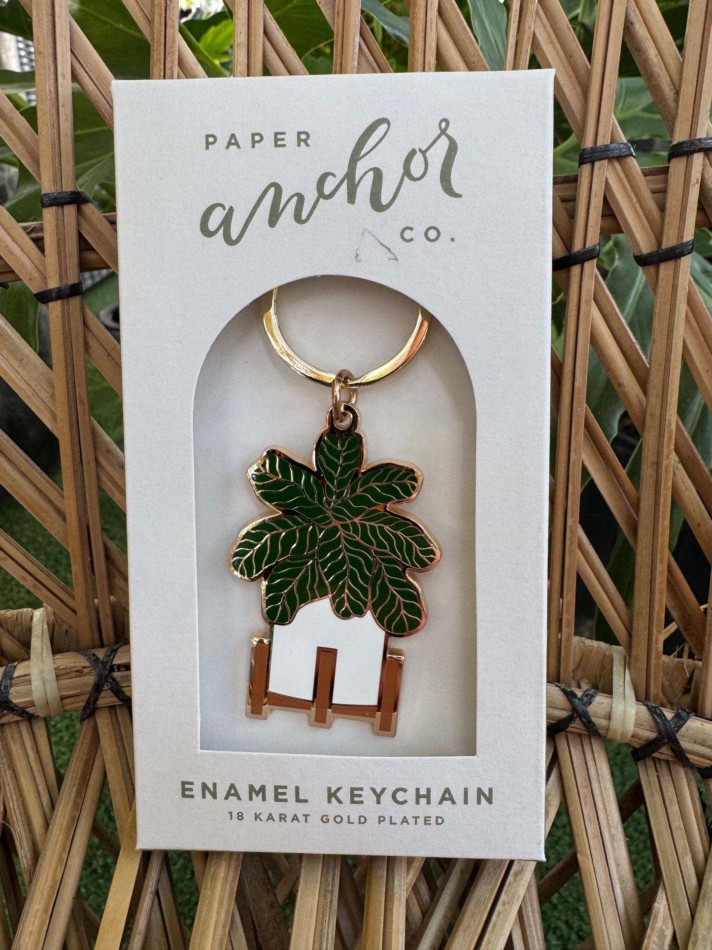 Keychain with leaf design in a Paper Anchor Co. packaging on a woven background