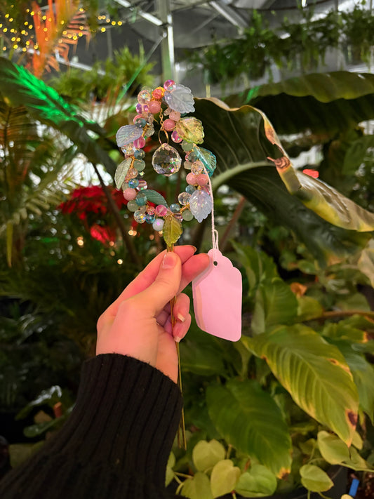 decorative beaded plant stake sun catcher with pink, blue and green beads and a central crystal