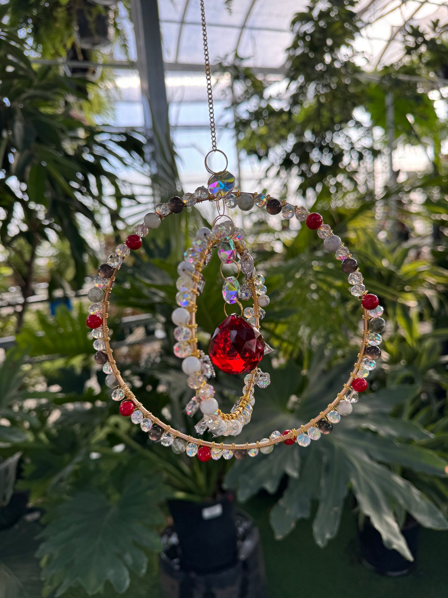 decorative red and white sun catcher beaded along two hoops 