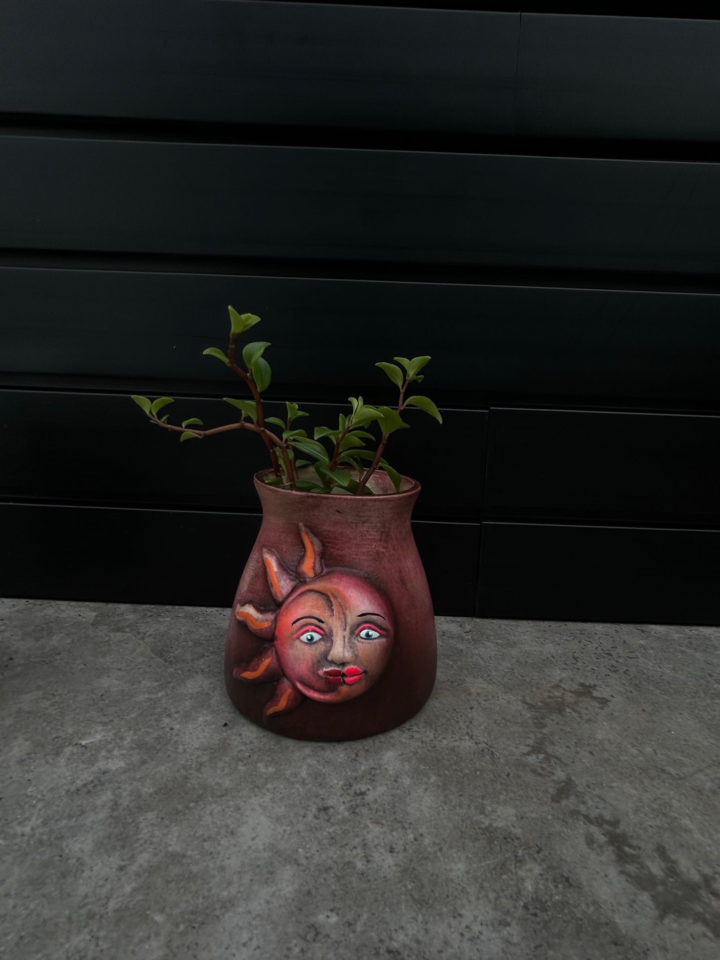 small red ceramic planter with a sun and moon design