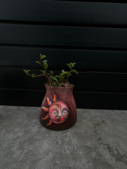 small red ceramic planter with a sun and moon design