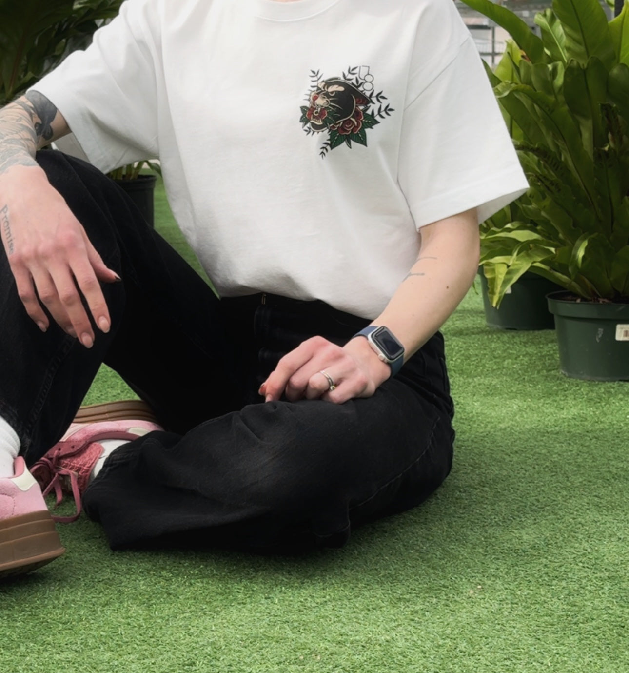 a person wearing a white t-shirt with a traditional style panther design