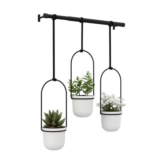 A set of three white cylindrical hanging planters with green plants, suspended from a black rod.