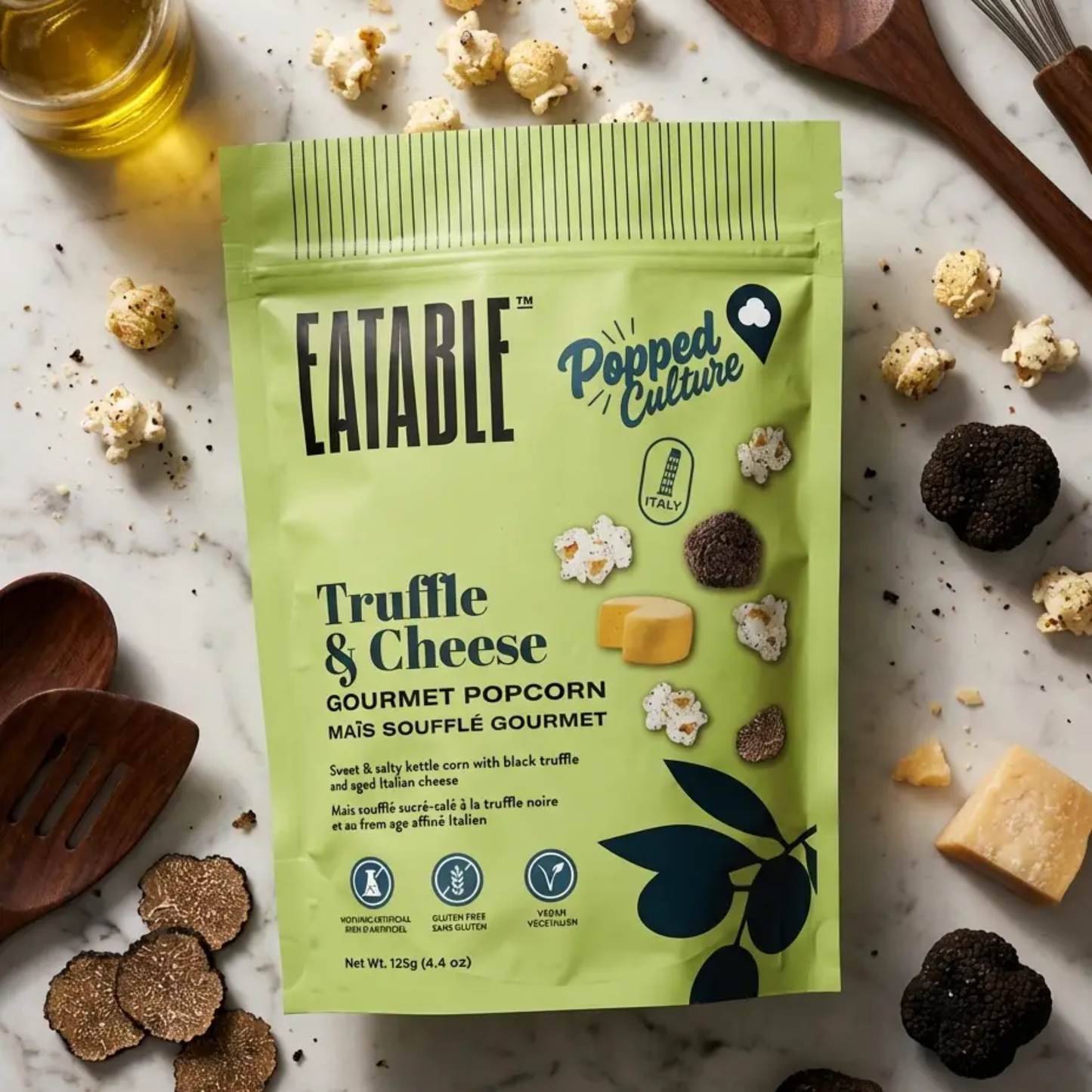 eatable Truffle & Cheese gourmet popcorn package on a marble surface with truffles and cheese.